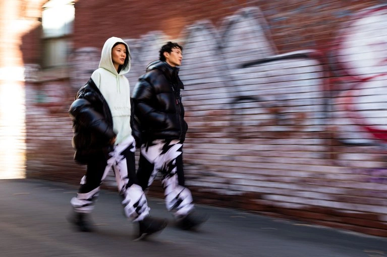 парень и девушка идут по улице в одежде из одной серии