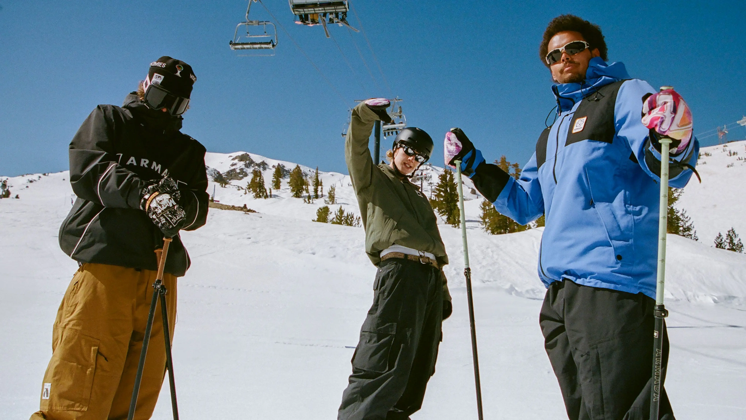 три лыжника в одежде armada стоят на горнолыжном склоне