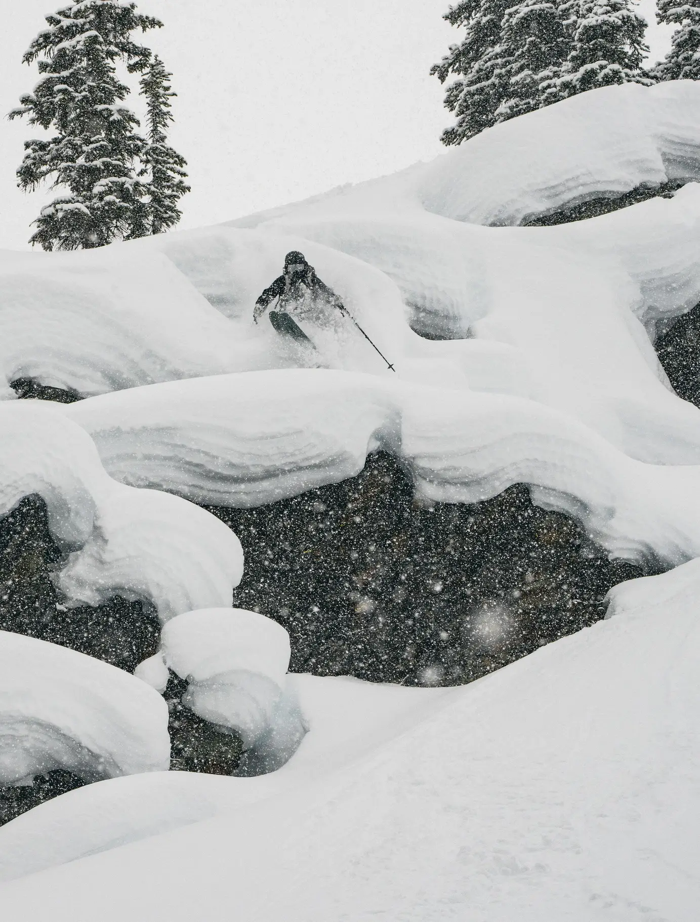лыжник фрирайдер прыгает по снежным подушкам