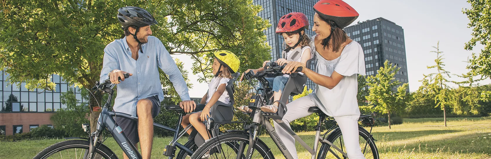 семья с детьми на велосипедах в городском парке