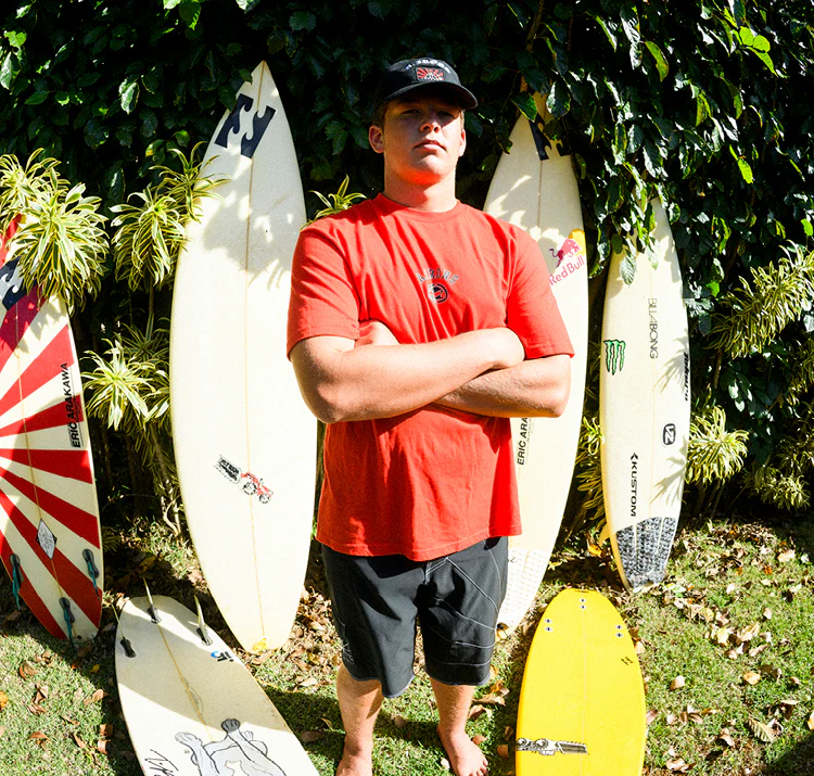 мужчина на пляже с серфами на заднем плане