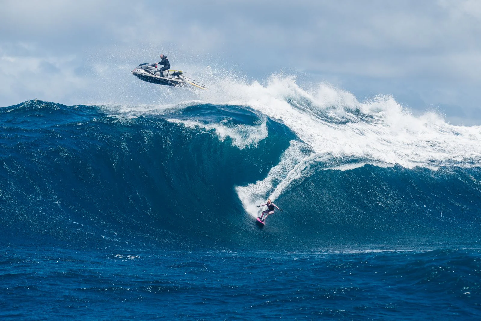 гидроцикл и девушка на серфе на большой волне