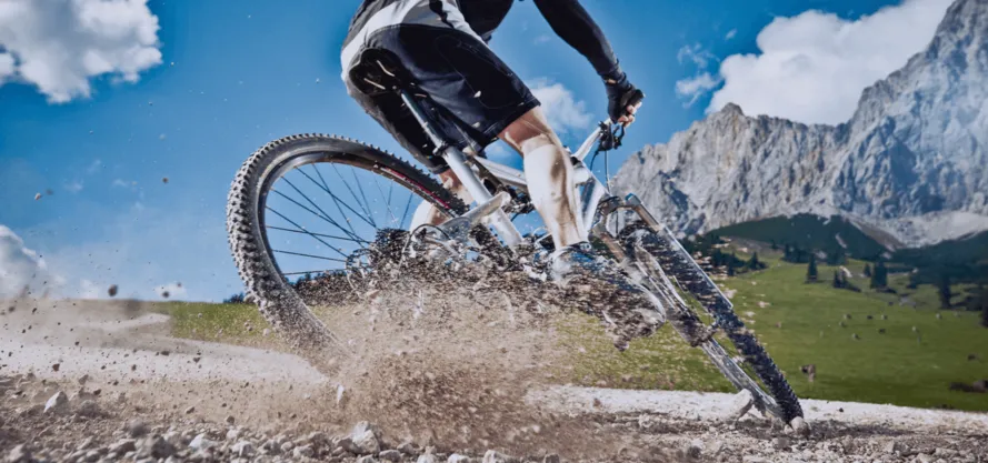 Велосипедист мчится по каменстой дороге.