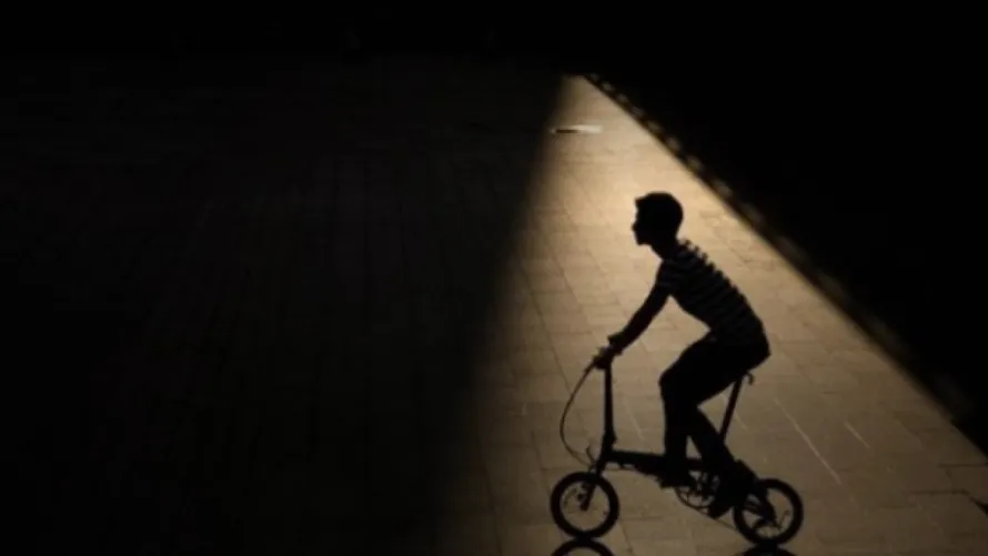 Мужчина катается на складном велосипеде компании DAHON.