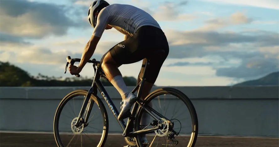 Велосипедист едет на велосипеде компании DAHON.