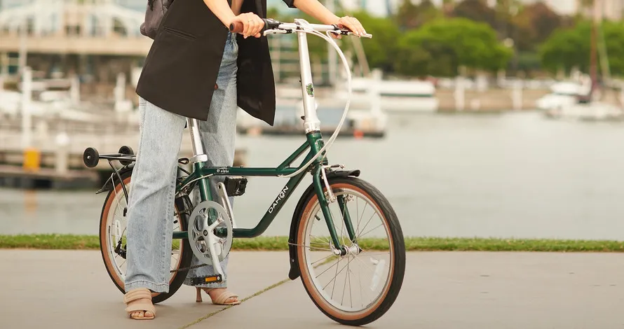 Девушка на складном велосипеде производства компании DAHON