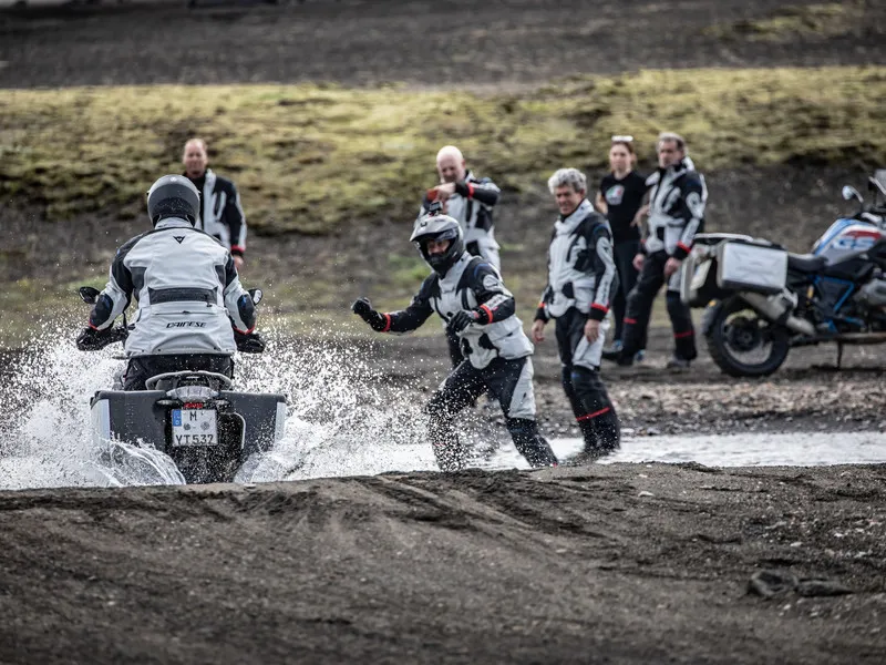 Участники проекта Experience компании DAINESE следят за прохождением мотоциклиста на мотоцикле водной преграды