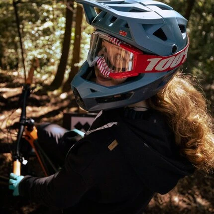 Девушка на велосипеде, оборачиваясь смотрит на фотографирующего.