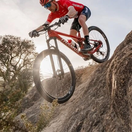 Велосипедист мчится с горки на велосипеде с колесами производства DT SWISS.