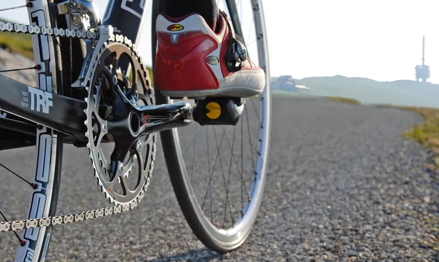 Вид на ведущую звезду велосипеда, едущего по асфальту на колесах производства DT SWISS.