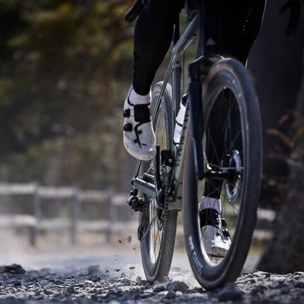 Велосипедист мчится на велосипеде с вилкой производства DT SWISS.