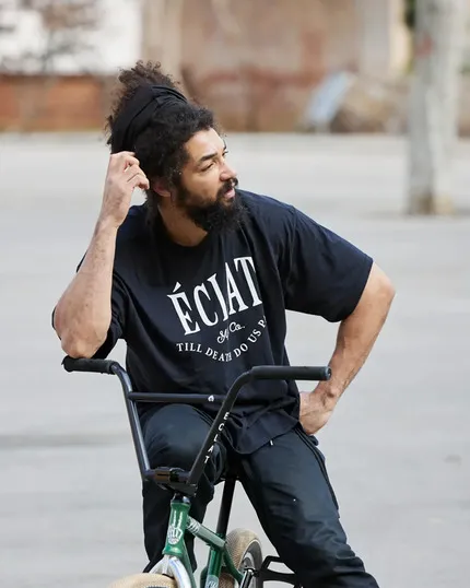 Алекс Кеннеди (Alex Kennedy) сидит на велосипеде BMX.