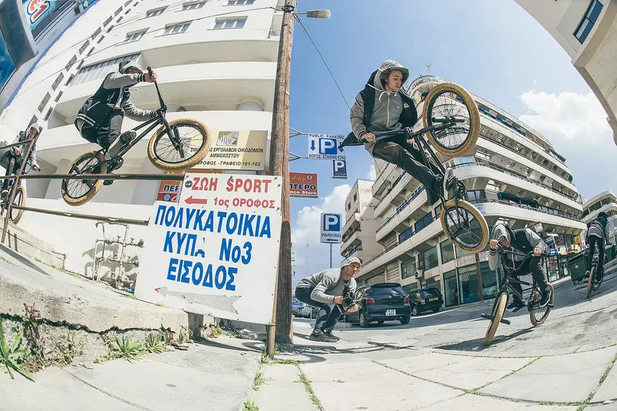 Спорстмены выполняют трюки на велосипедах BMX на улице города.