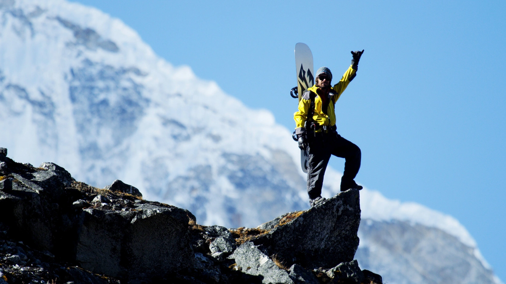 Джереми Джонс на вершине горы машет рукой