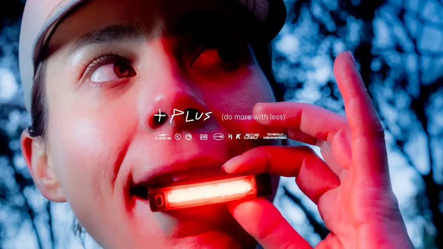 Девушка держит в зубах фонарик компании KNOG.