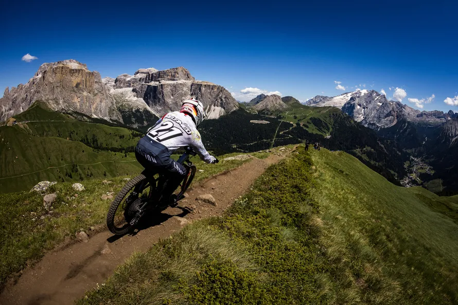 Велосипедист едет по горам на велосипеде с поркышками компании MAXXIS