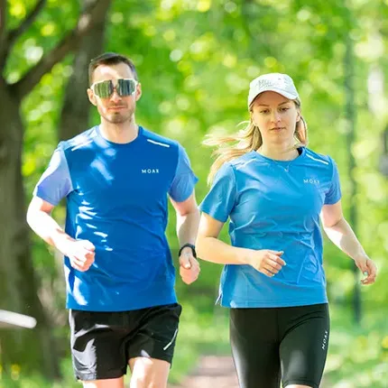Мужчина и девушка бегут в экипировке компании MOAX.