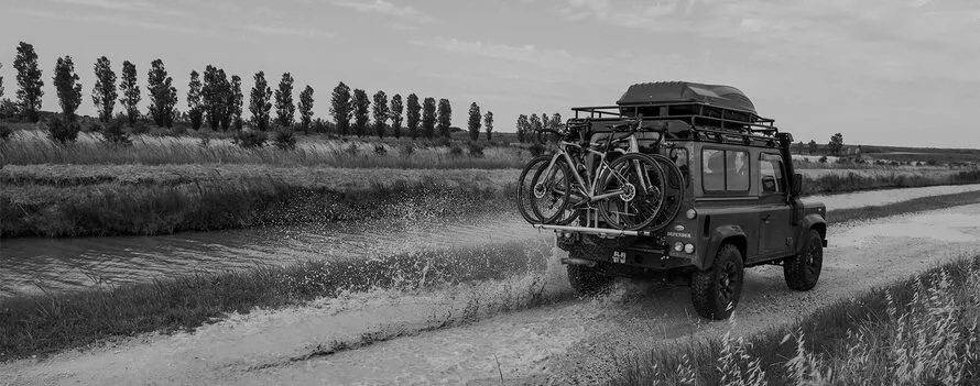 Велокрепление компании Peruzzo с несколькими велосипедами, установленное сзади на джипе