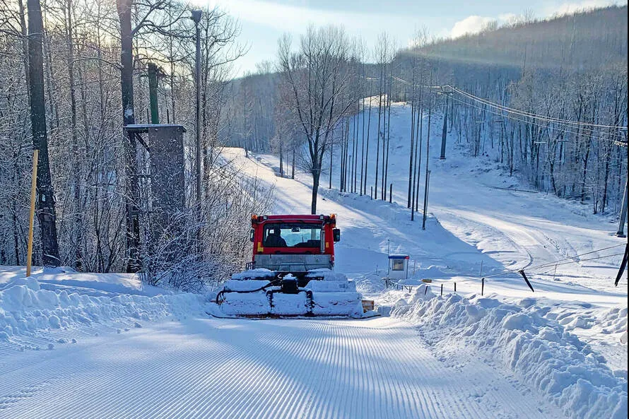 Ратрак (снегоуплотнительная машина) уплотняет снег на Горнолыжном комплексе «СОК» (Красная Глинка).