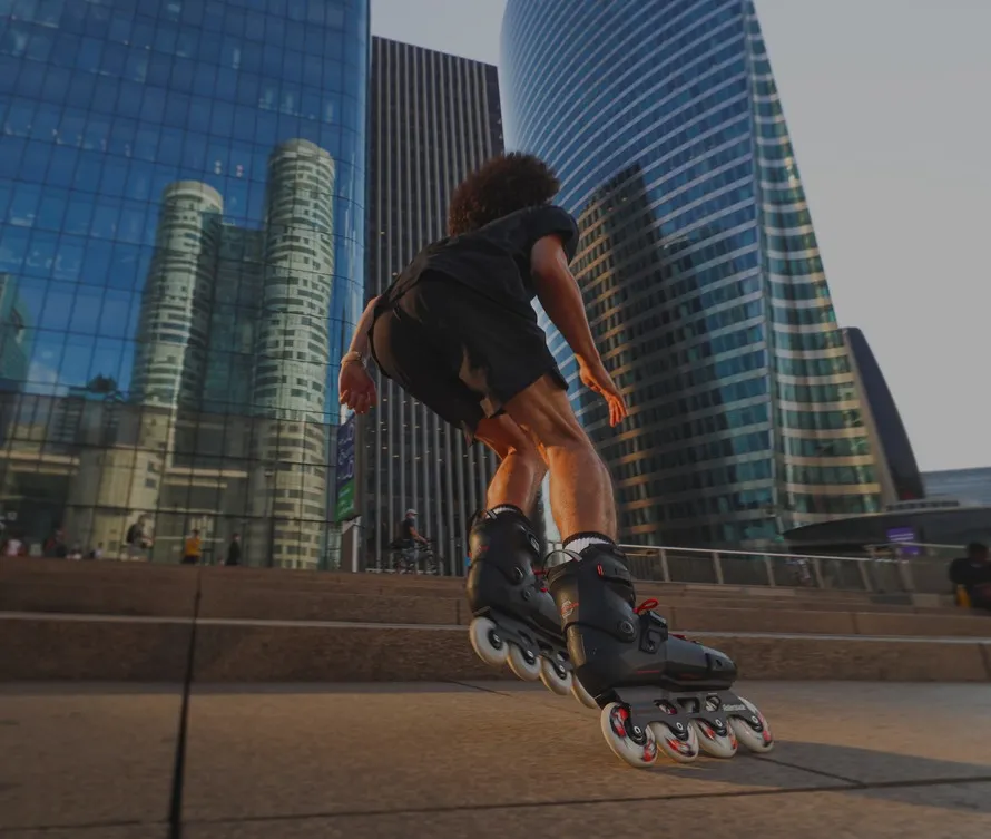 Мужчина катается по улице города на роликовых коньках компании Rollerblade