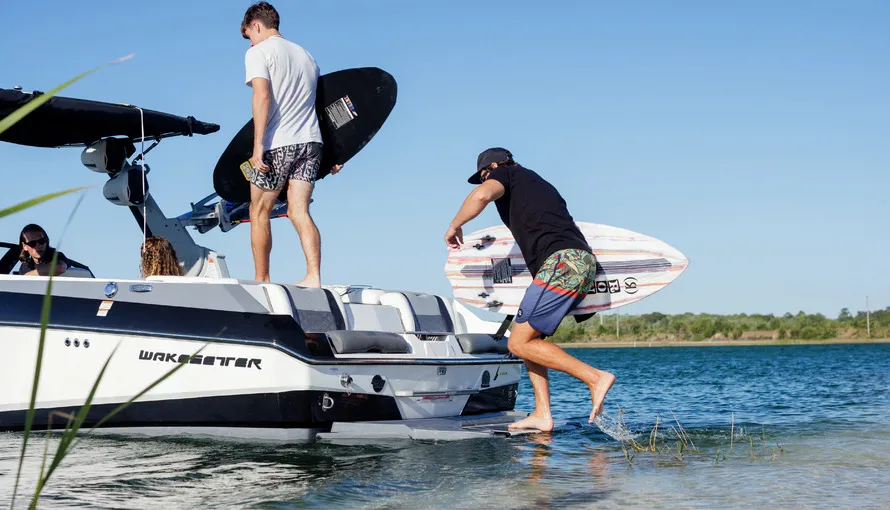 Ребята грузятся на катер с вейкбордингами компании RONIX