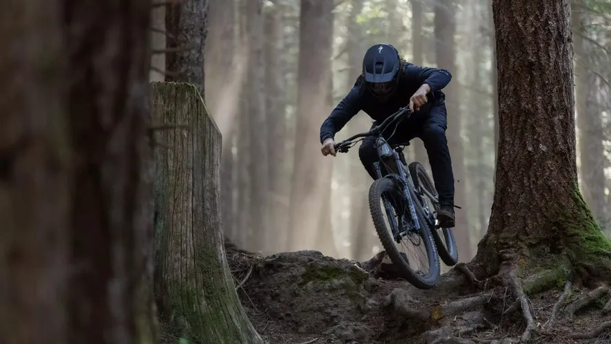 Спортсмен спускается в лесу на велосипеде с колесами Roval Traverse