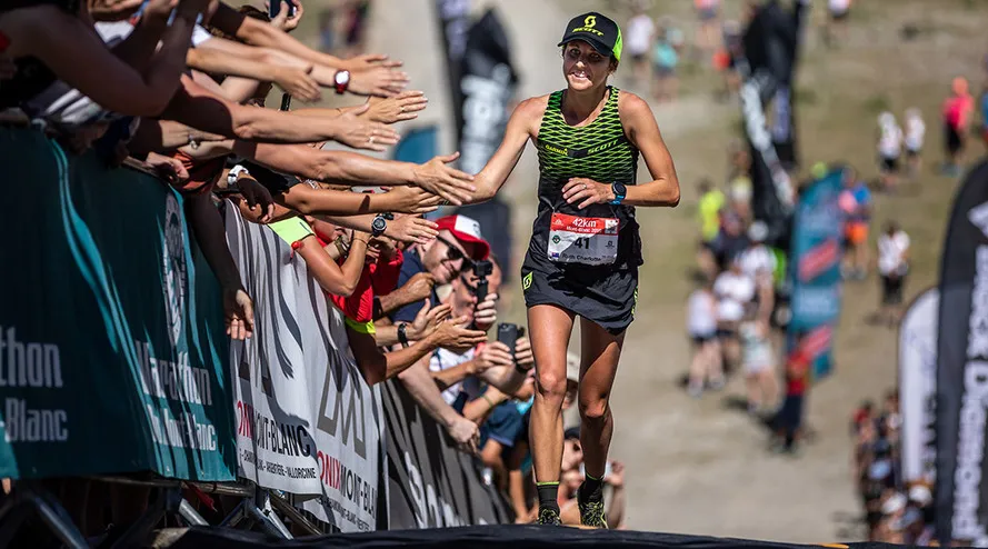 Новозеландка РУТ КРОФ и зрители приветствуют друг друга.