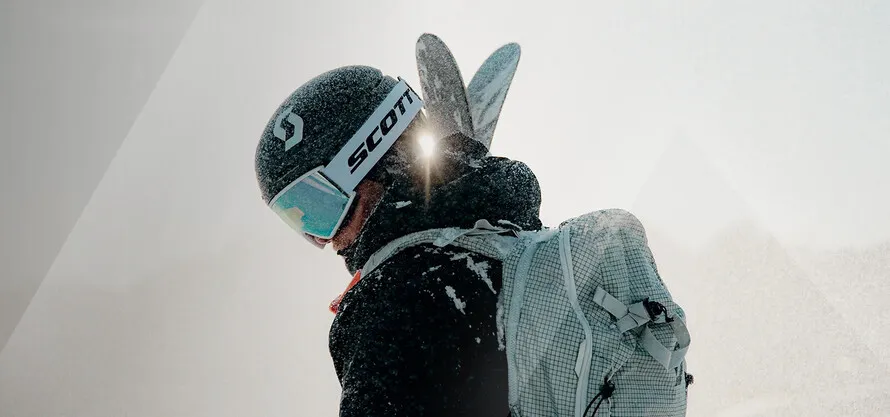 Горнолыжник в экипировке и с рюкзаком компании SCOTT.