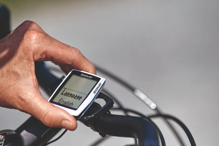 Переключение режима выбора отображаемого языка на велокомпьютере производства компании SIGMA крупным планом.