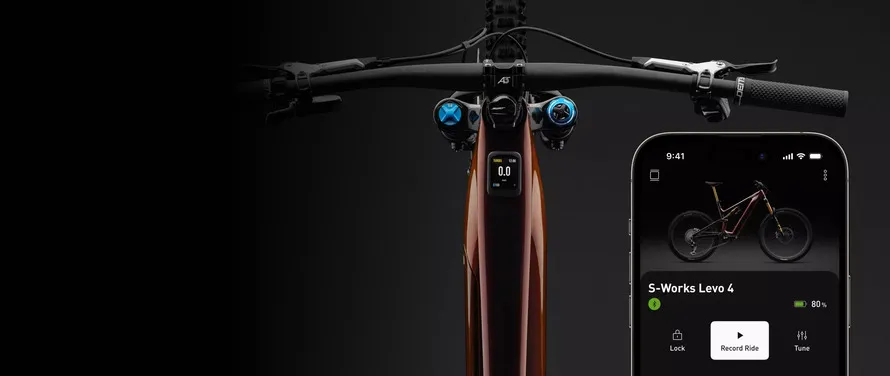 Велосипед Specialized и мобильный телефон со специализированным приложением, включающим отслеживание эффективности и управление электровелосипедом Turbo.