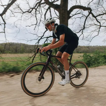 Велосипедист едет на велосипеде производства компании Specialized.