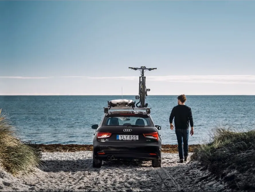 Мужчина рядом с автомобилем к креплением на крыше компании THULE.