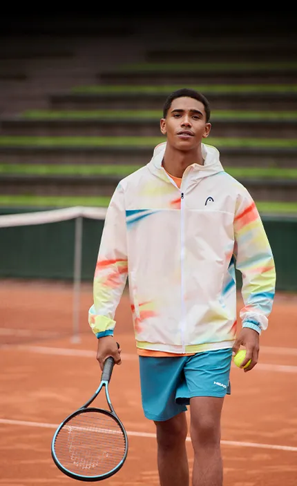 Теннисист с ракеткой для большого тенниса и в экипировке бренда HEAD.