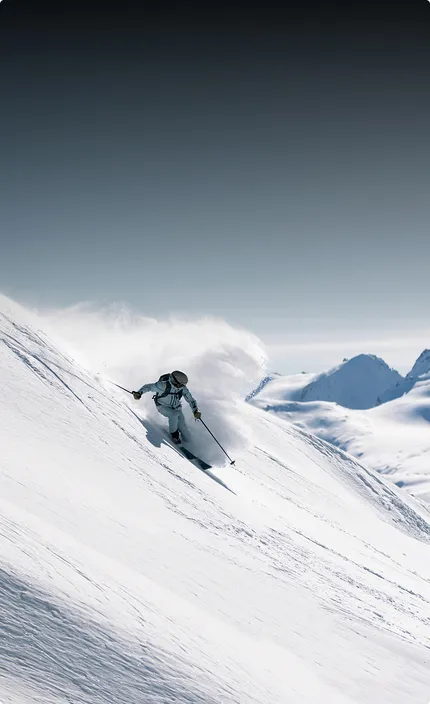 Фрирайдер спускается с заснеженной горы на горных лыжах бренда HEAD и с креплениями производства компании TYROLI.