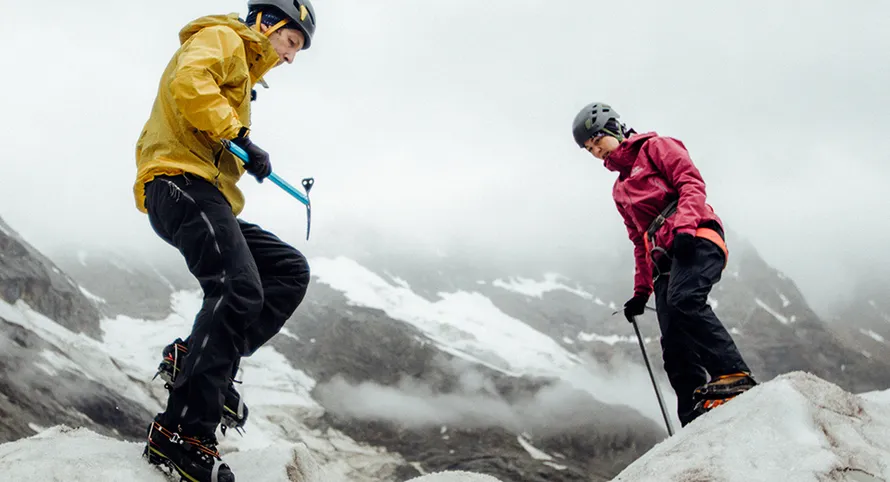Мужчина и женщина на снежном склоне в средствах индивидуальной защиты и со снаряжением компании VENTO.