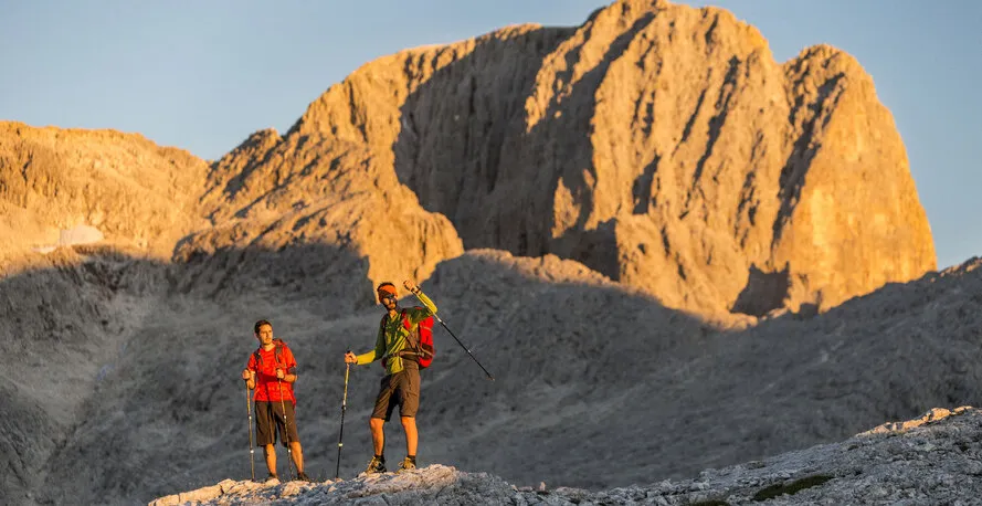 Двое мужчин стоят на склоне горы с треккинговыми палками компании VIPOLE.